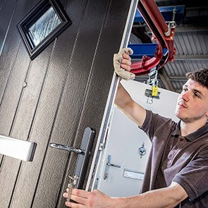 A skilled craftsperson in the composite door factory inspects and checks the door as it comes off the production line